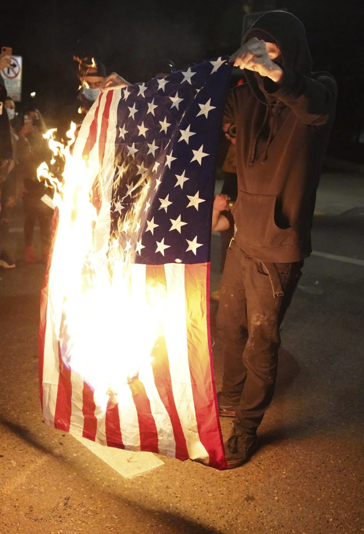A protester burns an American flag while rallying in downtown Portland, Ore., on Sept. 26, 2020. (Allison Dinner/AP Photo)