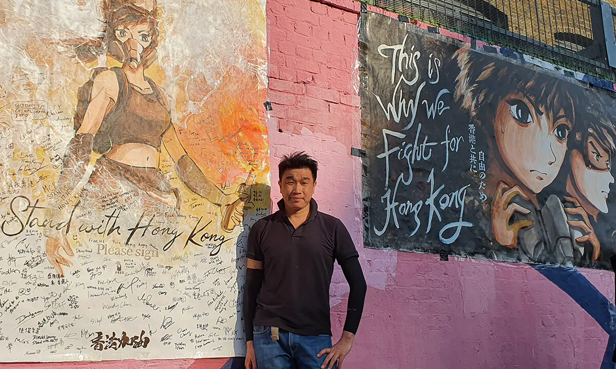 Otto Yuen, known in Hong Kong as The Lennon wall painter, poses with his hand-painted posters in London, on Sept. 20, 2020. (Lily Zhou/The Epoch Times)