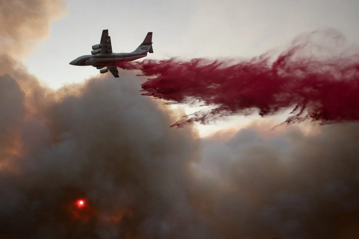The sun is seen through a cloud of smoke as an airplane drops red fire retardant on the Glass Fire in Deer Park, Calif., on Sept. 27, 2020. (Adrees Latif/Reuters)