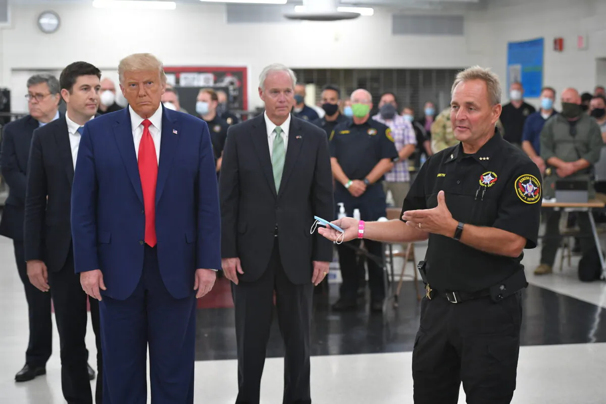 Kenosha County Sheriff David Beth, right, speaks while President Donald Trump, center, Sen. Ron Johnson (R-Wis.), second from right, and others listen, at at Mary D. Bradford High School in Kenosha, Wis., on Sept. 1, 2020. (Mandel Ngan/AFP via Getty Images)