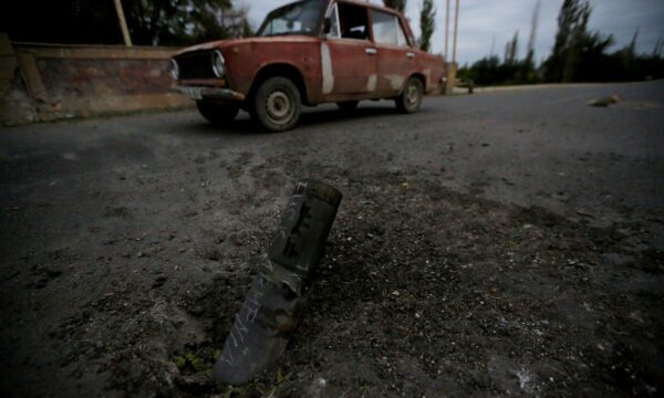 A car drives past the remains of spent ammunition following a recent shelling
