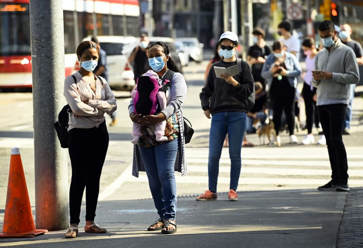 People wait in line for hours outside a COVID-19 assessment centre at St. Michael's Hospital in Toronto on Sept. 28, 2020. (The Canadian Press/Nathan Denette)