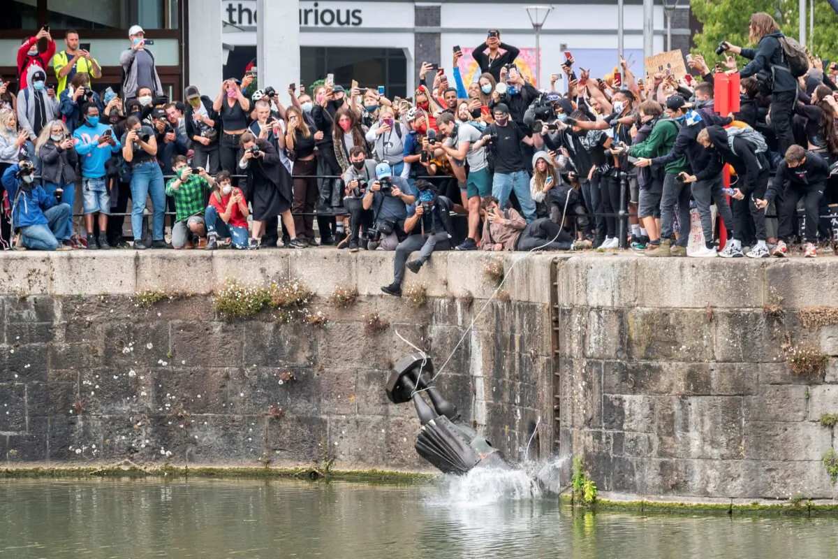 The statue of 17th century merchant, Edward Colston, falls into the water during a Black Lives Matter protest in Bristol, England, on June 7, 2020.  (Keir Gravil via Reuters)

