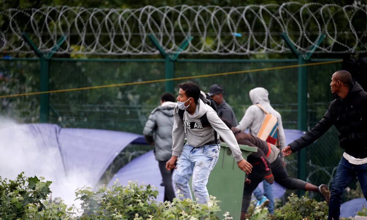 Migrants confront French police officers as police dismantle a makeshift shelter camp in Calais, France, on Jul. 10, 2020. (Pascal Rossignol/Reuters)