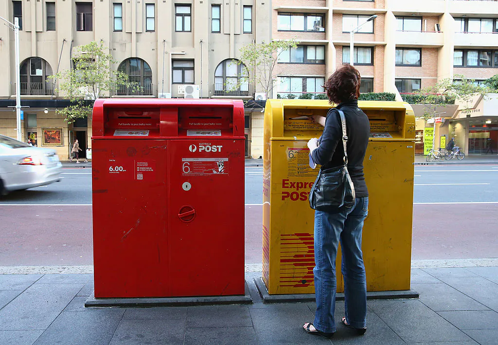 A woman posts mail via an Express Post box located on Oxford st outside the Darlinghurst Post Office on May 7, 2014 in Sydney, Australia. (Don Arnold/Getty Images)
