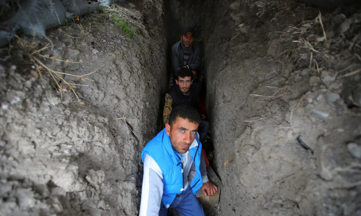 Local residents take shelter in a dugout during the fighting over the breakaway region of Nagorno-Karabakh in the city of Terter, Azerbaijan, on Sept. 30, 2020. (Aziz Karimov/Reuters)