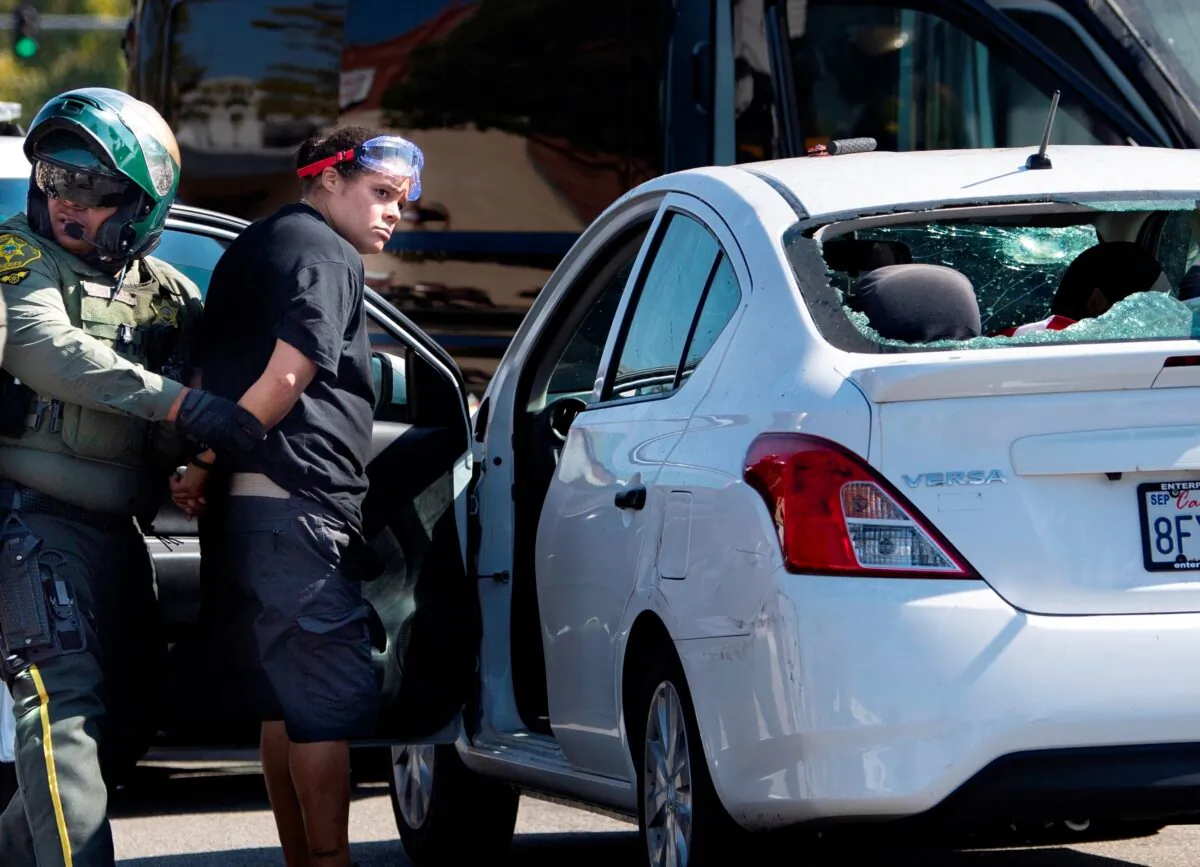 Tatiana Turner is taken into custody after witnesses said she drove her car into a crowd of protesters in Yorba Linda, Calif., on Sept. 26, 2020. (Mindy Schauer/The Orange County Register via AP)