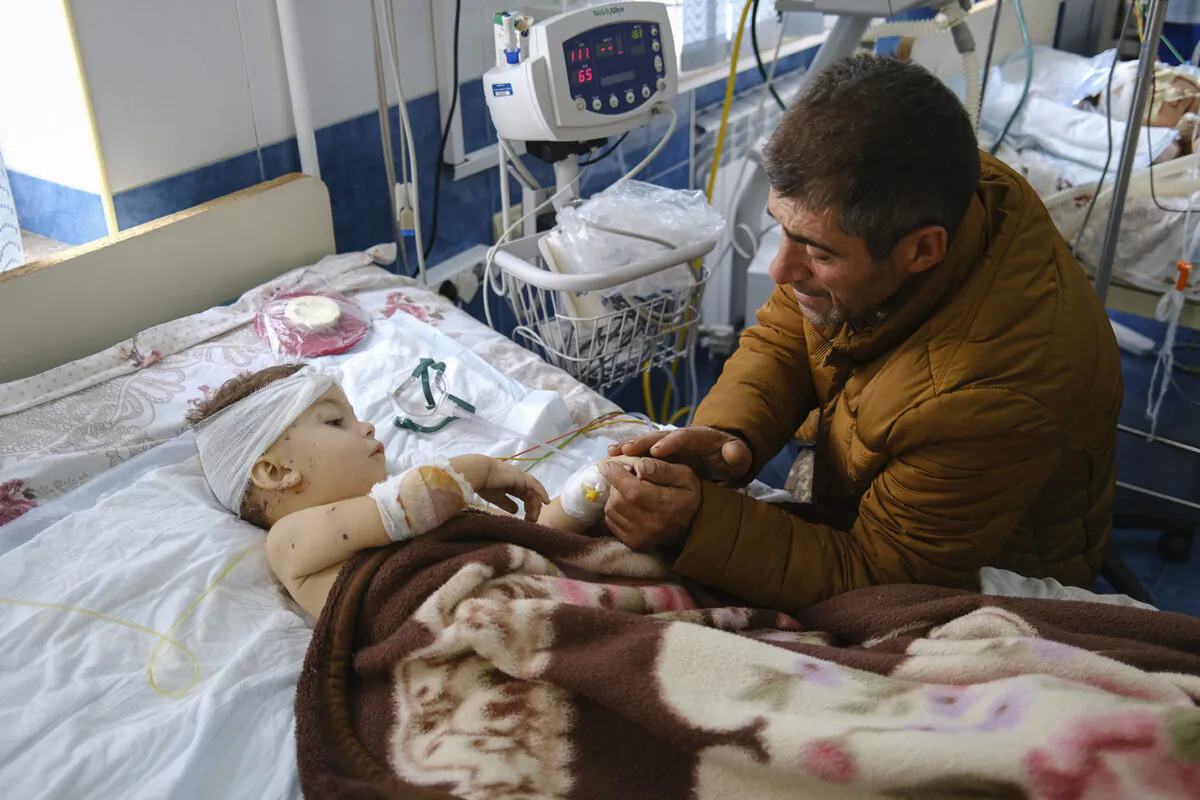 A man speaks with his child, wounded during shelling, in Stepanakert, the self-proclaimed Republic of Nagorno-Karabakh, Azerbaijan on Sept. 28, 2020. (Areg Balayan/PAN Photo via AP)