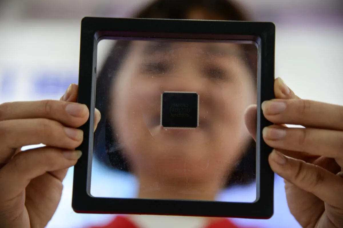 A Chinese employee holds a self-developed chip at a industrial park in Jinan in China's eastern Shandong Province, on May 11, 2019. (STR/AFP via Getty Images)