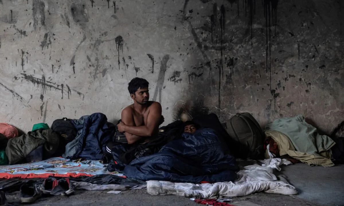 Bangladeshi migrants rest inside an abandoned factory near Velika Kladusa, Bosnia, on Sept. 30, 2020. (Marko Djurica/Reuters)