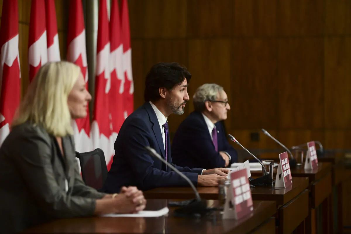 Prime Minister Justin Trudeau is flanked by Minister of Infrastructure and Communities Catherine McKenna (L), and Chair of the Board of the Canada Infrastructure Bank Michael Sabia, during a press conference in Ottawa on Oct. 1, 2020. (Sean Kilpatrick/The Canadian Press)
