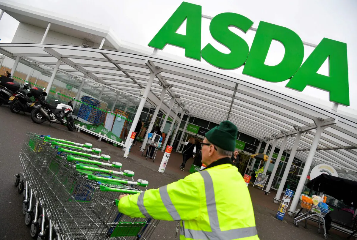 A worker pushes shopping trolleys at an Asda store in West London, Britain, on April 28, 2018. (Toby Melville/Reuters)