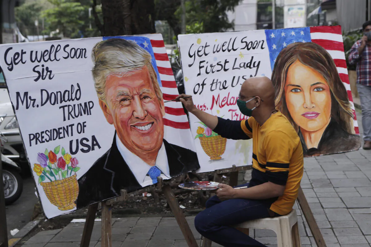 An artist paints a poster carrying a get-well message for U.S. President Donald Trump and First Lady Melania in Mumbai, India, on Oct. 2, 2020. (AP Photo/Rajanish Kakade)