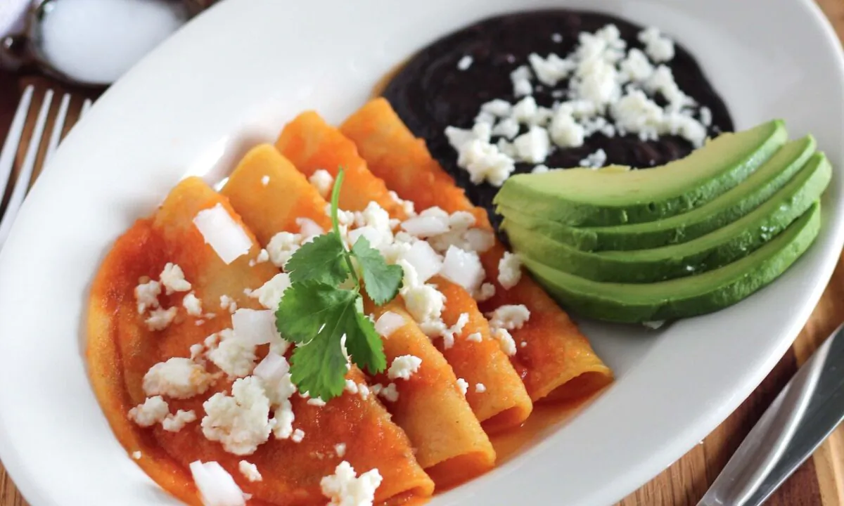 Entomatadas, corn tortillas that are folded or rolled, stuffed with cheese, and covered in a tomato sauce. were one of Martinez's mother's favorite quick and easy dishes to make for lunch. (Courtesy of Mely Martínez)