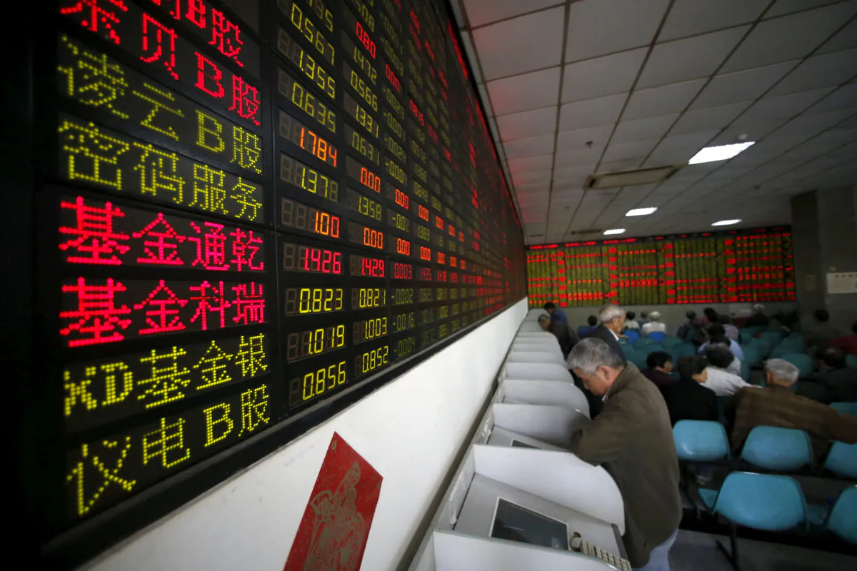 Investors look at computer screens showing stock information at a brokerage house in Shanghai, China, April 21, 2016. (Aly Song/Reuters)