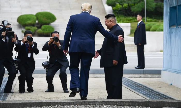 President Donald Trump steps into the northern side of the Military Demarcation Line that divides North and South Korea, as North Korea's leader Kim Jong Un looks on, in the Joint Security Area of Panmunjom in the Demilitarized zone, on June 30, 2019. (Brendan Smialowski/AFP via Getty Images)
