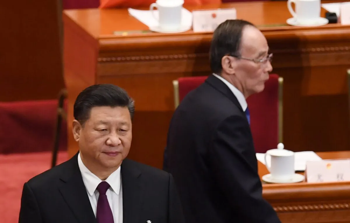 China's leader Xi Jinping (L) stands as Wang Qishan (R), former secretary of the Central Commission for Discipline Inspection, arrives for CCP’s first session of the 13th National People's Congress in Beijing, China on March 17, 2018. (GREG BAKER/AFP via Getty Images)