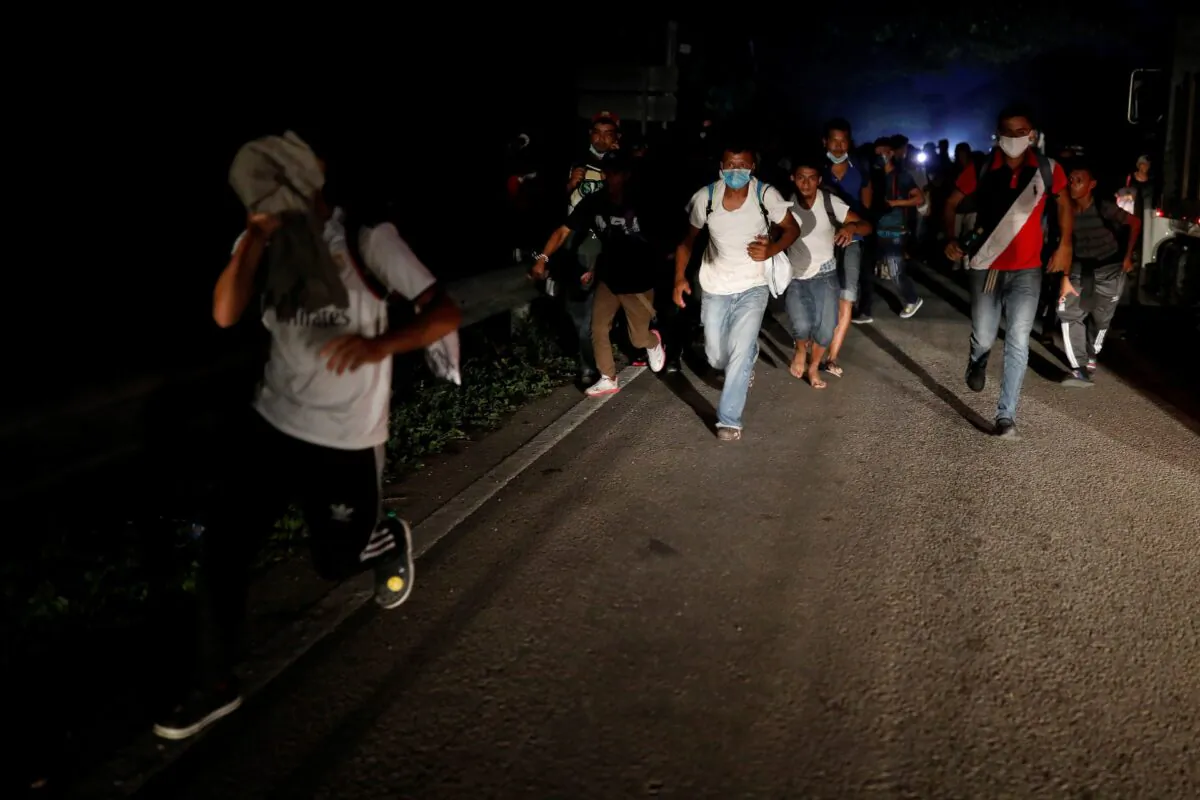 Honduran migrants trying to reach the U.S. run away after hurling stones to Guatemalan soldiers blocking a road to stop migrants from reach the Mexico's border, in San Pedro Cadenas, Izabal, Guatemala, on Oct. 2, 2020. (Luis Echeverria/Reuters) 