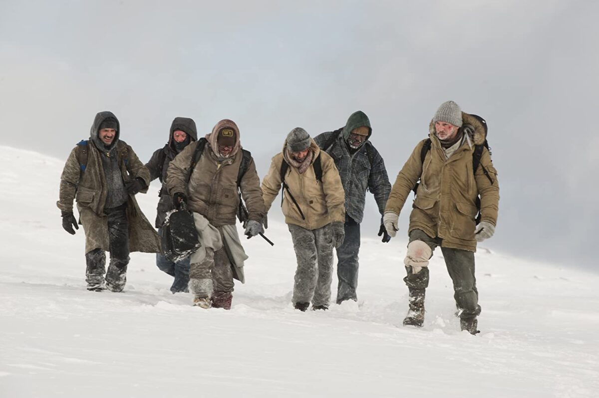 6 men walk in the snow in "The Grey"