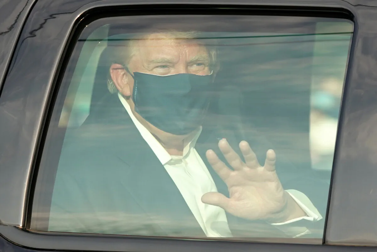 A car with President Donald Trump drives past supporters in a motorcade outside of Walter Reed Medical Center in Bethesda, Md., on Oct. 4, 2020. (Alex Edelman/AFP via Getty Images)