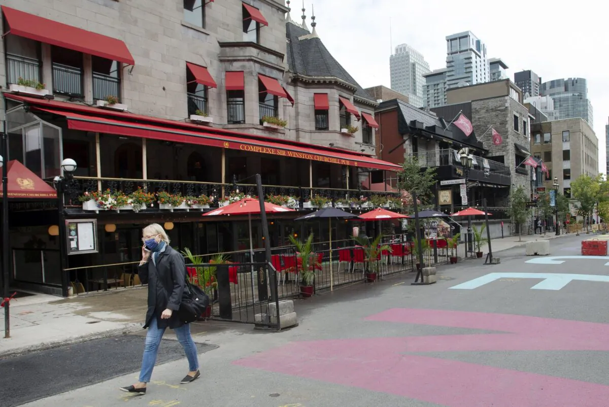 A woman walks past bars on Crescent Street in Montreal on Sept. 30, 2020. A 28-day lockdown of bars and restaurants in the city began on Oct. 1.
(The Canadian Press/Ryan Remiorz)