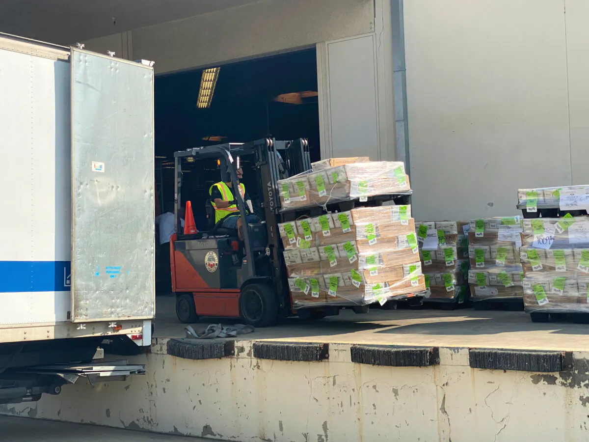 A forklift prepares to load mail-in ballots onto a truck at a loading dock outside the Orange County Registrar's office in Santa Ana, Calif., on Oct. 5, 2020. (Jamie Joseph/The Epoch Times)