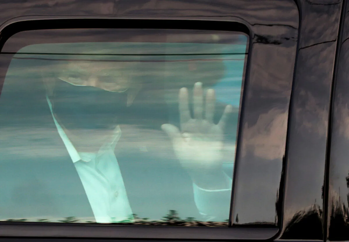 President Donald Trump waves to supporters as he briefly rides by in the presidential motorcade in front of Walter Reed National Military Medical Center, where he is being treated for COVID-19, in Bethesda, Md., on Oct. 4, 2020. (Cheriss May/Reuters)