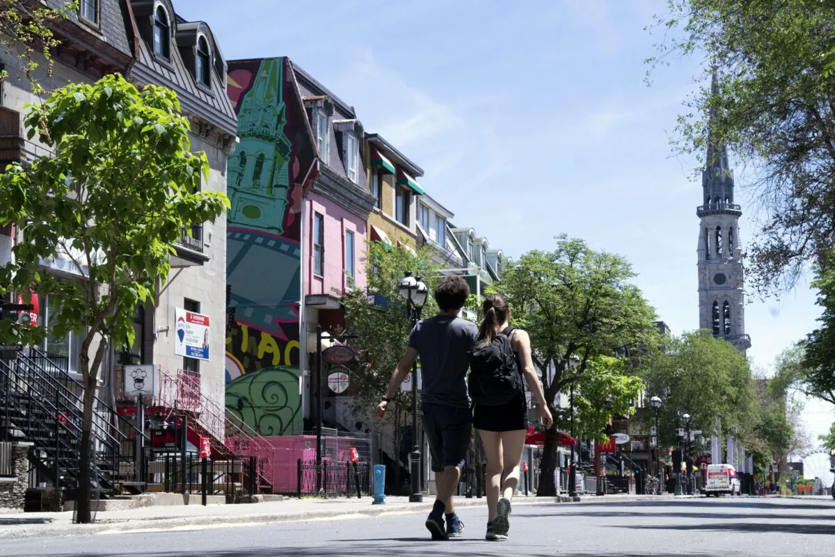 A couple stroll down a near-empty St-Denis Street in Montreal, closed to traffic in efforts to attract patrons, on June 8, 2020. Economists are advising fiscal discipline and spending reforms as Canada’s deficit soars. (The Canadian Press/Paul Chiasson)