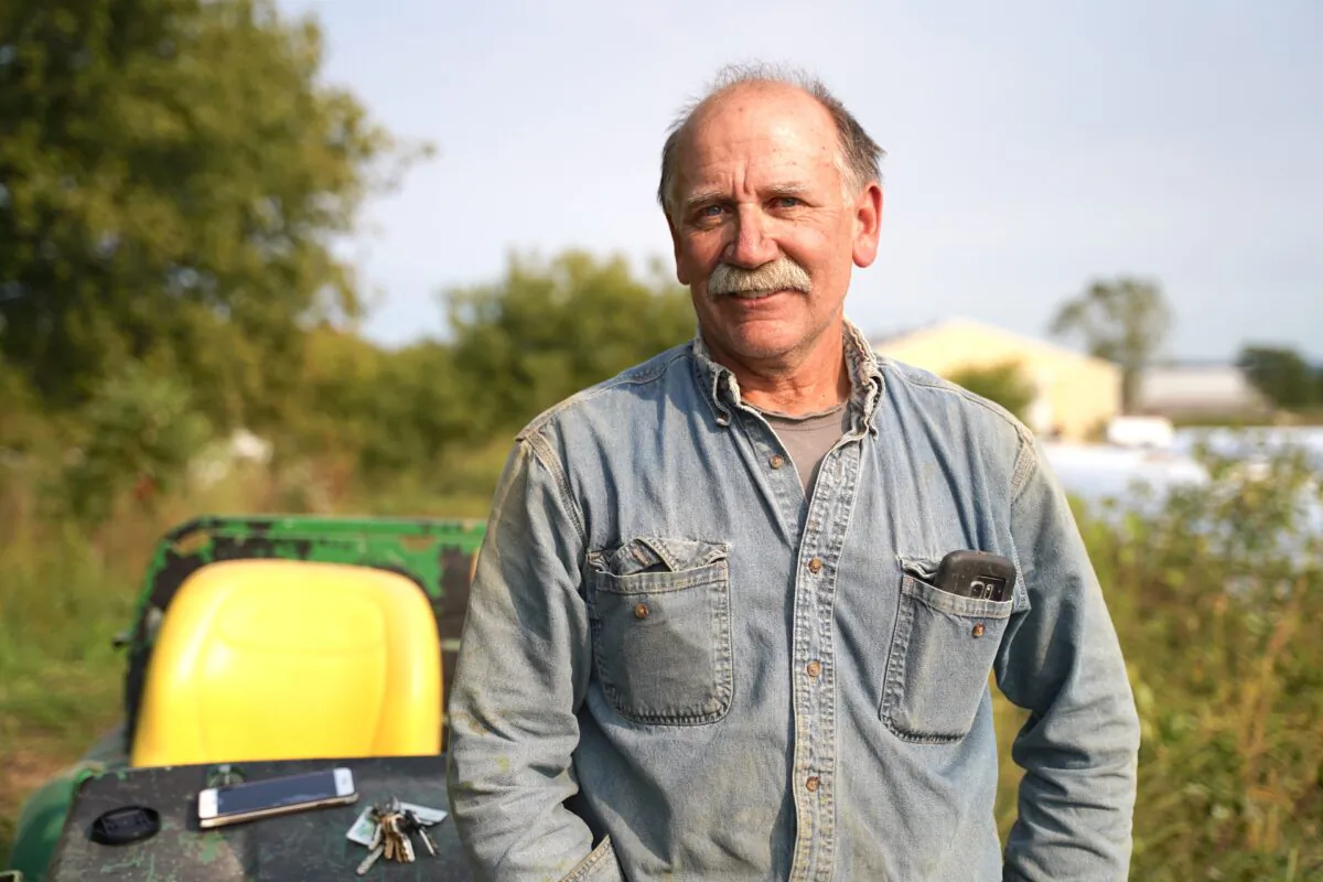 Cary Moser sits on his John Deer tractor on his dairy farm in Westby, Wis., on Sept. 17, 2020. (Cara Ding/The Epoch Times)