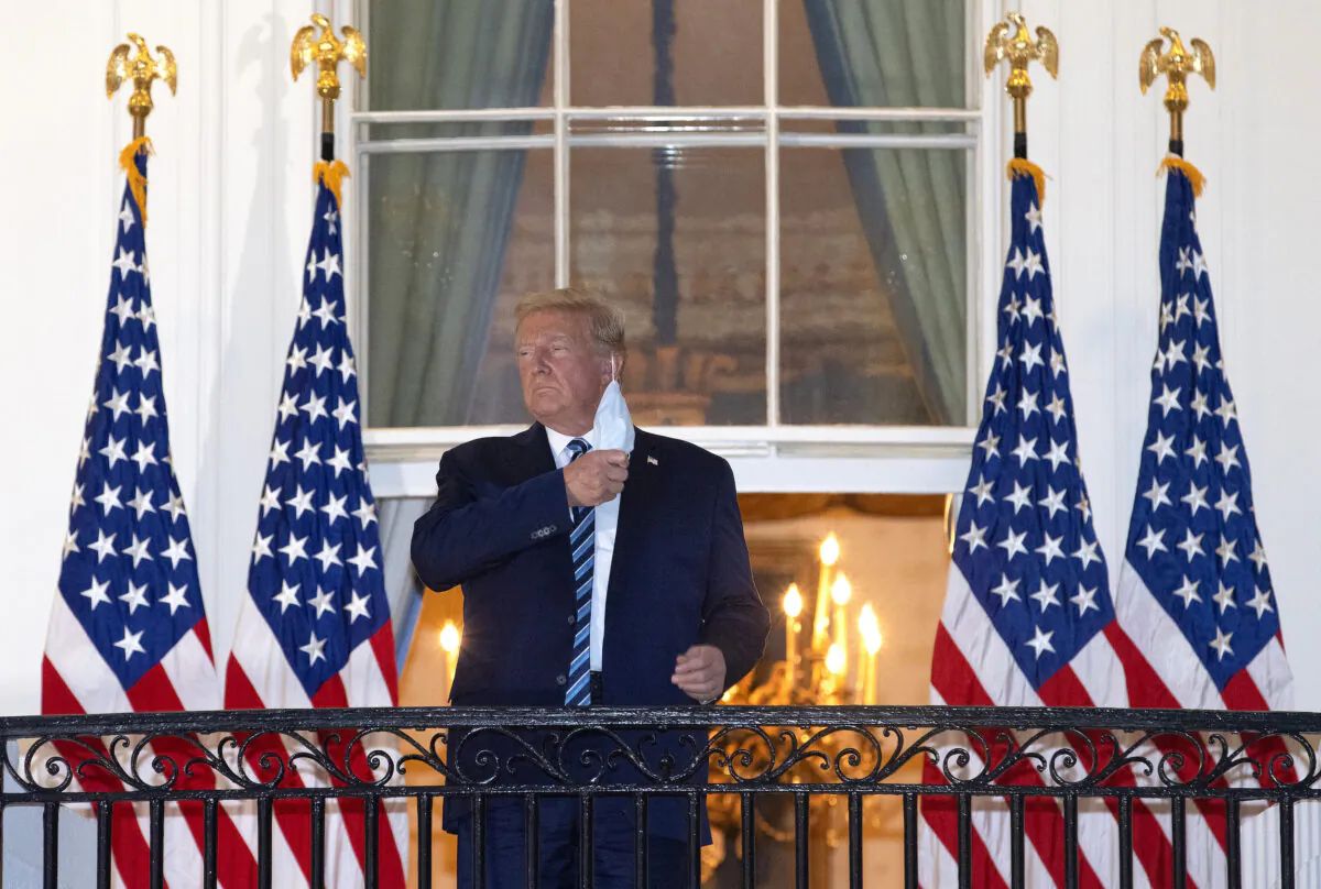 President Donald Trump removes his mask upon return to the White House from Walter Reed National Military Medical Center in Washington on Oct. 5, 2020. (Win McNamee/Getty Images)