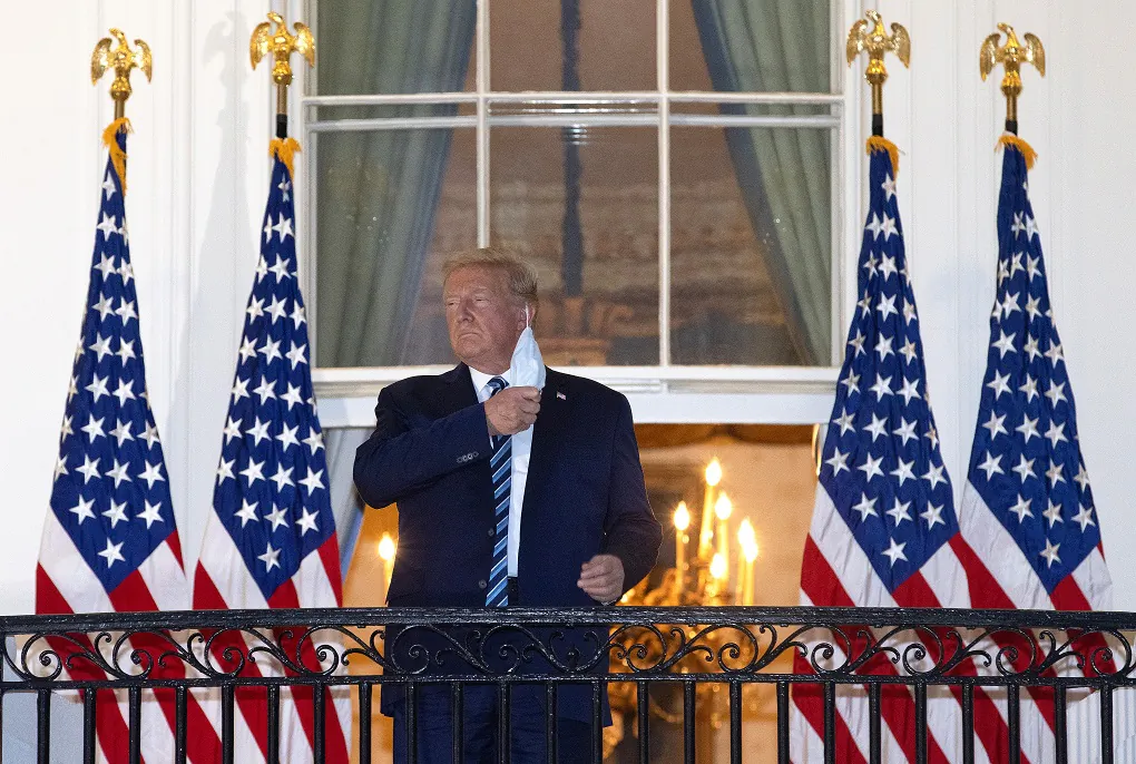 President Donald Trump removes his mask upon return to the White House from Walter Reed National Military Medical Center on Oct. 5, 2020. (Win McNamee/Getty Images)
