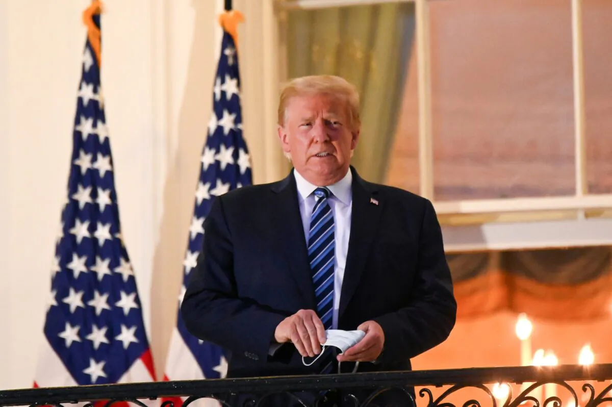 President Donald Trump poses on the Truman Balcony of the White House after returning from being hospitalized at Walter Reed Medical Center for COVID-19 treatment in Washington on Oct. 5, 2020. (Erin Scott/Reuters)