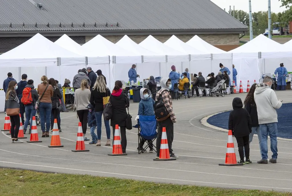 People lineup at a COVID-19 testing site Friday, September 25, 2020 in St. Lambert, Que. (Ryan Remiorz/The Canadian Press)