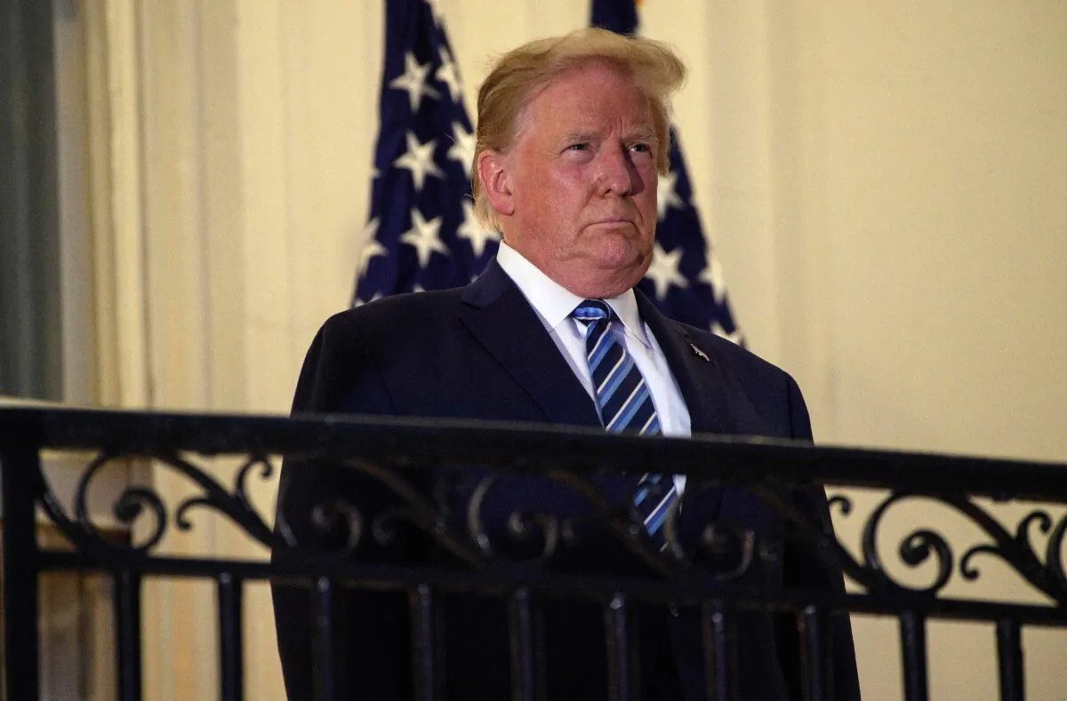 President Donald Trump looks out from the Truman Balcony upon his return to the White House from Walter Reed Medical Center, where he underwent treatment for COVID-19, in Washington on Oct. 5, 2020. (Nicholas Kamm/AFP via Getty Images)