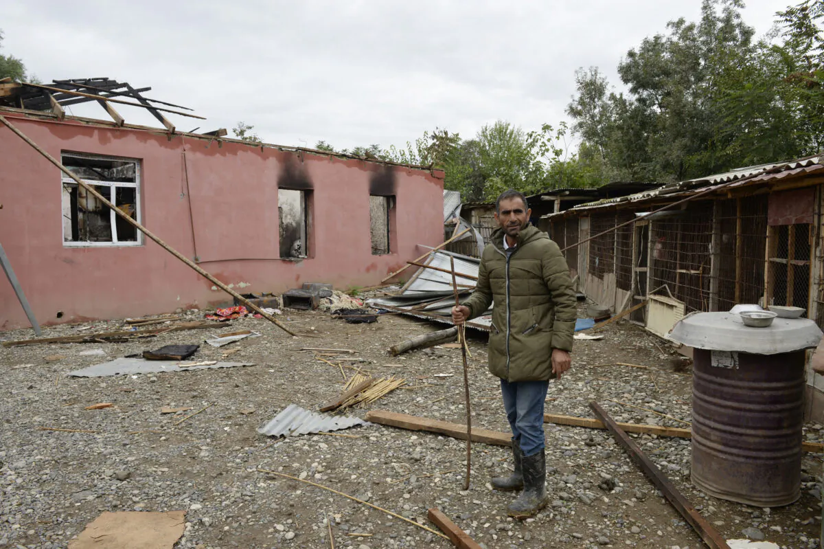 A man stands in front of a house damaged by shelling during the ongoing fighting between Armenia and Azerbaijan over the breakaway Nagorno-Karabakh region, in the village of Alkhanly in Azerbaijan's Fuzuli district on Oct. 7, 2020. (Tofik Babayev/AFP via Getty Images)