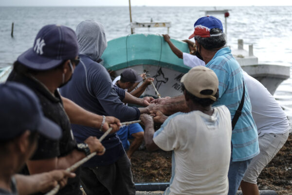 Fishermen pull in a boat