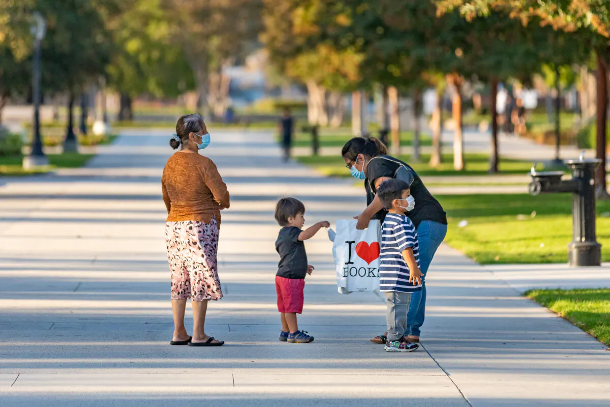 A family walks away from a book drive at the public library in Westminster, Calif., on Sept. 22, 2020. (John Fredricks/The Epoch Times) 