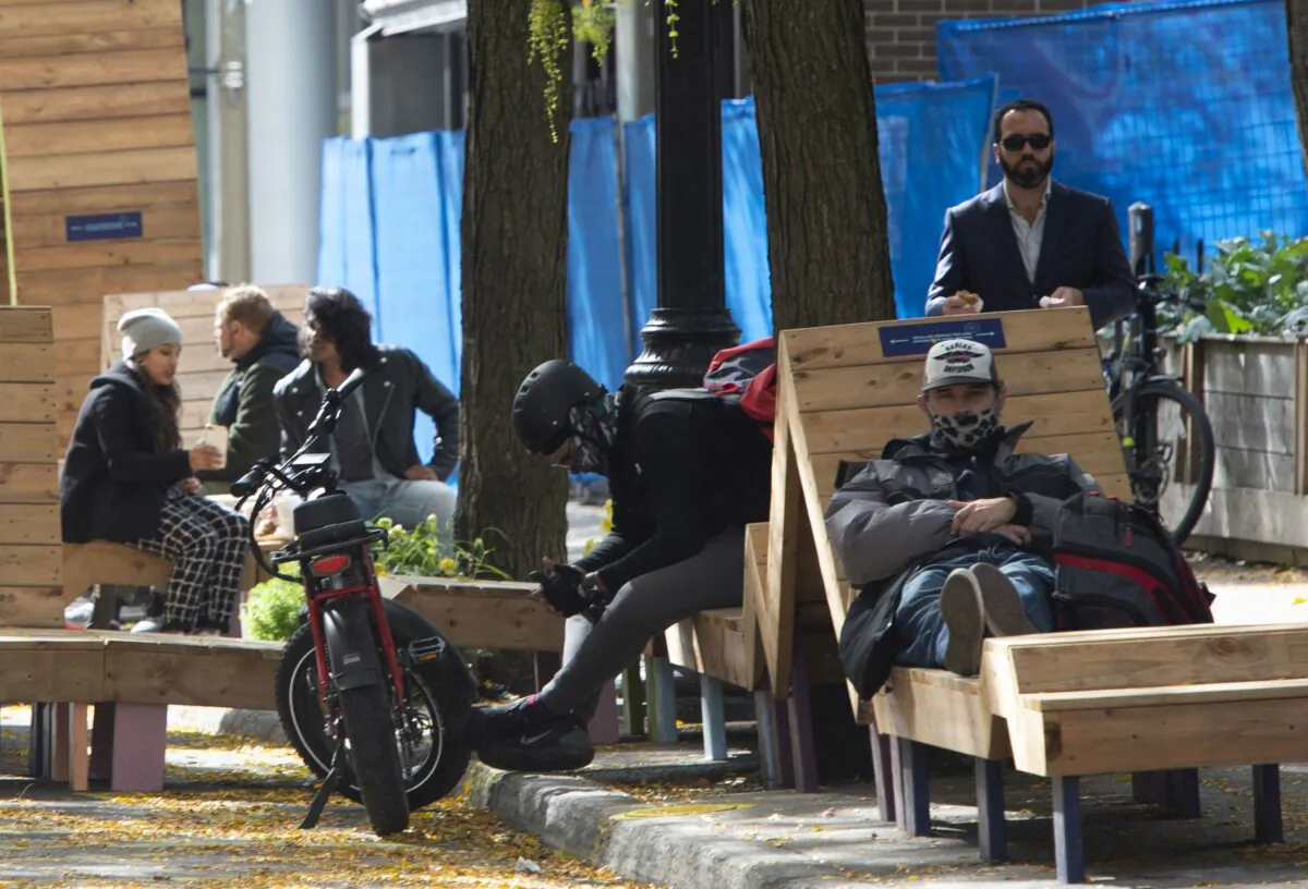 People relax on Saint Catherine Street in Montreal on the first day of a 28-day lockdown of bars and restaurants in the city, on October 1, 2020. (The Canadian Press/Ryan Remiorz)