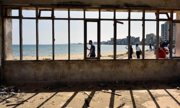People awalk on a abandoned beach in Varosha
