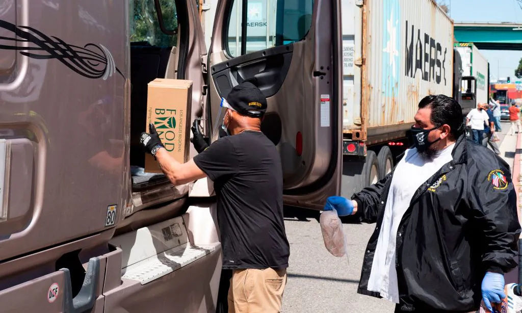 Teamsters Union members and the Los Angeles Regional Food Bank distribute food to hundreds of port truck drivers impacted by the COVID-19 pandemic during a mobile drive-through food pantry in Long Beach, Calif., on April 22, 2020. (Robyn Beck/AFP via Getty Images)
