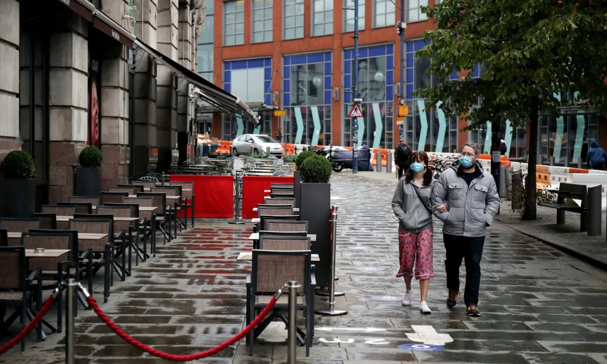People wearing protective masks walk in Manchester, Britain, on Aug. 4, 2020. (Molly Darlington/Reuters)
