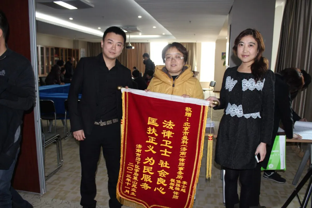 Homeowners express gratitude to Zhang Shichao (left) for protecting their property rights through legal means, in Jinan, in November 2013. (Courtesy of Zhang Shichao)