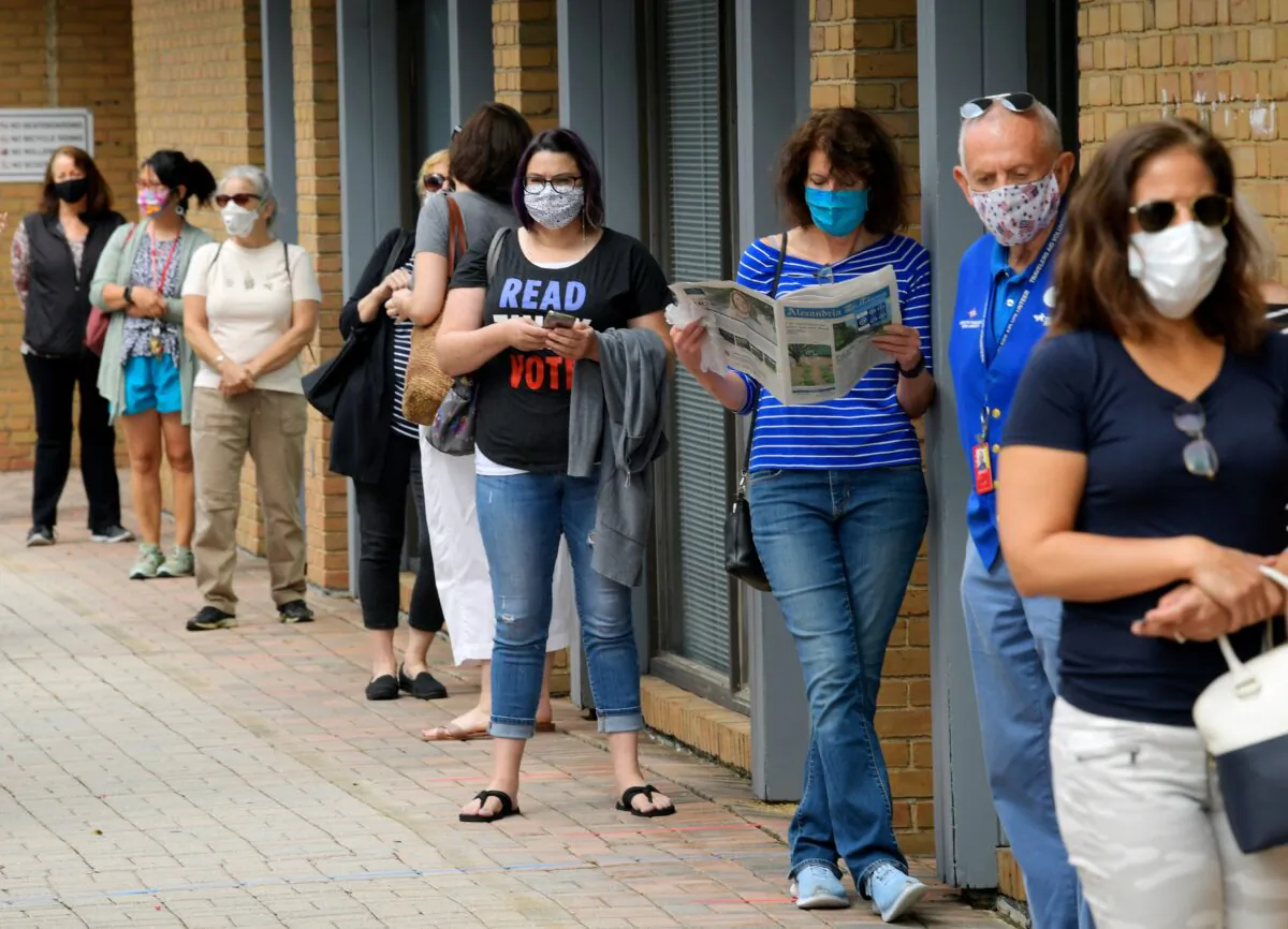 Alexandria residents wait in a socially distanced line to cast their ballots for the November presidential election on first day of early voting in Virginia, at the Voter Registration Office in Alexandria, Va., on Sept. 18, 2020. (John McDonnell/The Washington Post via AP)