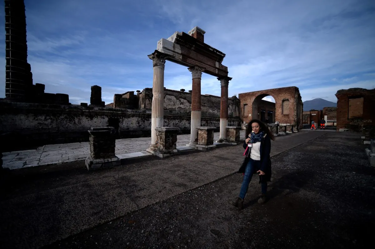 A visitor walks across the Roman Forum on November 25, 2019 in Pompeii. - While treasure hunters regularly pillaged Pompeii down the centuries looking for precious jewels or artifacts, whole areas have yet to be explored by modern-day archaeologists. (Photo by FILIPPO MONTEFORTE/AFP via Getty Images)