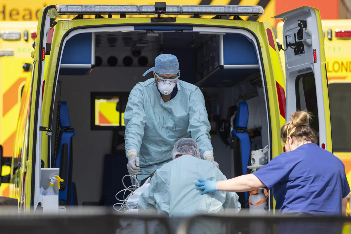 NHS workers in PPE take a patient with an unknown condition from an ambulance at St Thomas' Hospital in London on April 10, 2020. (Justin Setterfield/Getty Images)