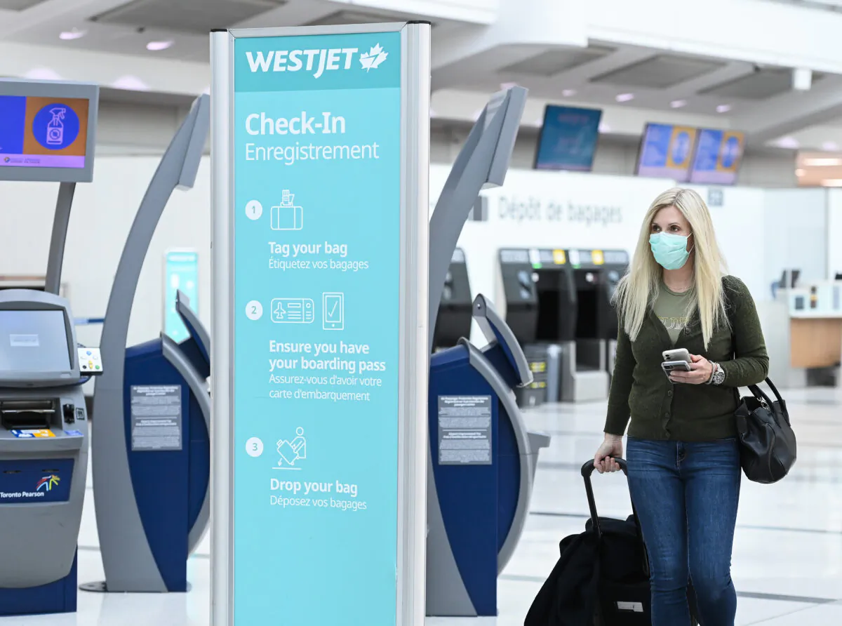 A woman walks through check in at WestJet at Pearson International airport during the COVID-19 pandemic in Toronto on Oct. 14, 2020. (The Canadian Press/Nathan Denette)