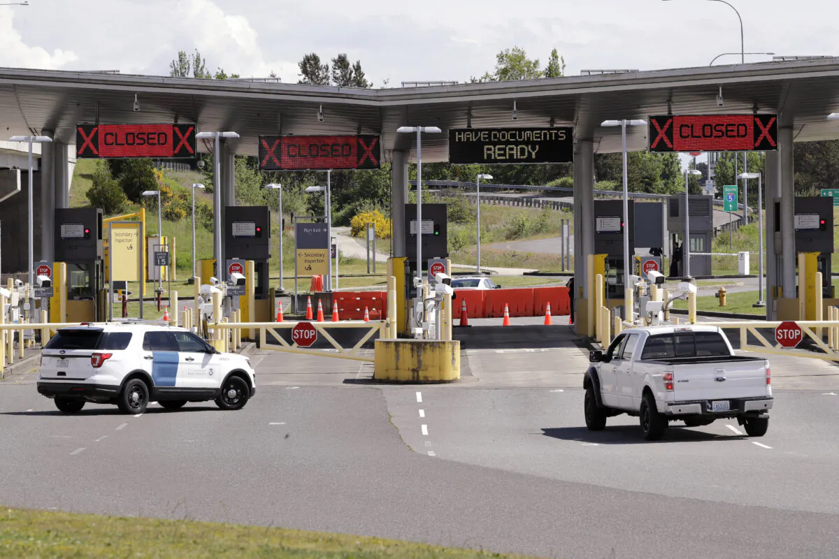 In this photo taken Sunday, May 17, 2020, a truck from Canada heads to the single open lane heading into the U.S. at the Peace Arch border crossing in Blaine, Wash. (AP Photo/Elaine Thompson)