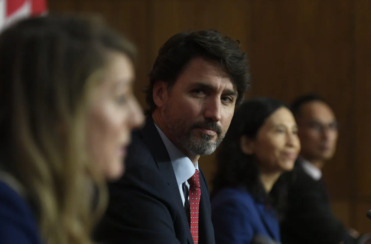 Prime Minister Justin Trudeau listens to Economic Development and Official Languages Minister Melanie Joly during a news conference in Ottawa on Oct. 2, 2020. (Adrian Wyld/The Canadian Press)
