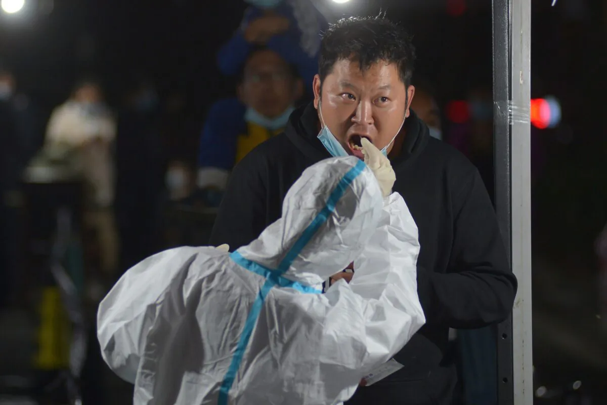A health worker takes a swab from a resident for COVID-19 nucleic acid test following a new outbreak of the coronavirus in Qingdao, eastern China's Shandong Province on Oct. 13, 2020. (STR/AFP via Getty Images)