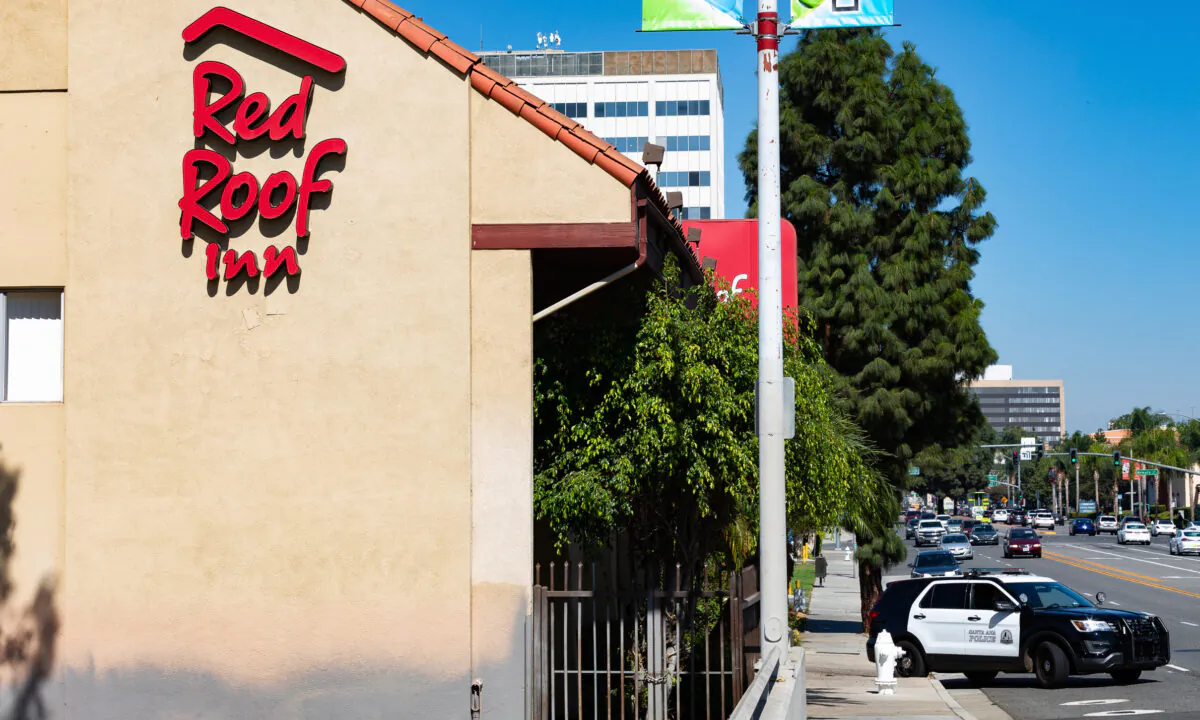 An Anaheim Police Department vehicle exits the driveway of the Red Roof Inn motel in Santa Ana, Calif., on Oct. 12, 2020. (John Fredricks/The Epoch Times)